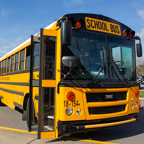 Student exiting the bus and wearing a backpack
